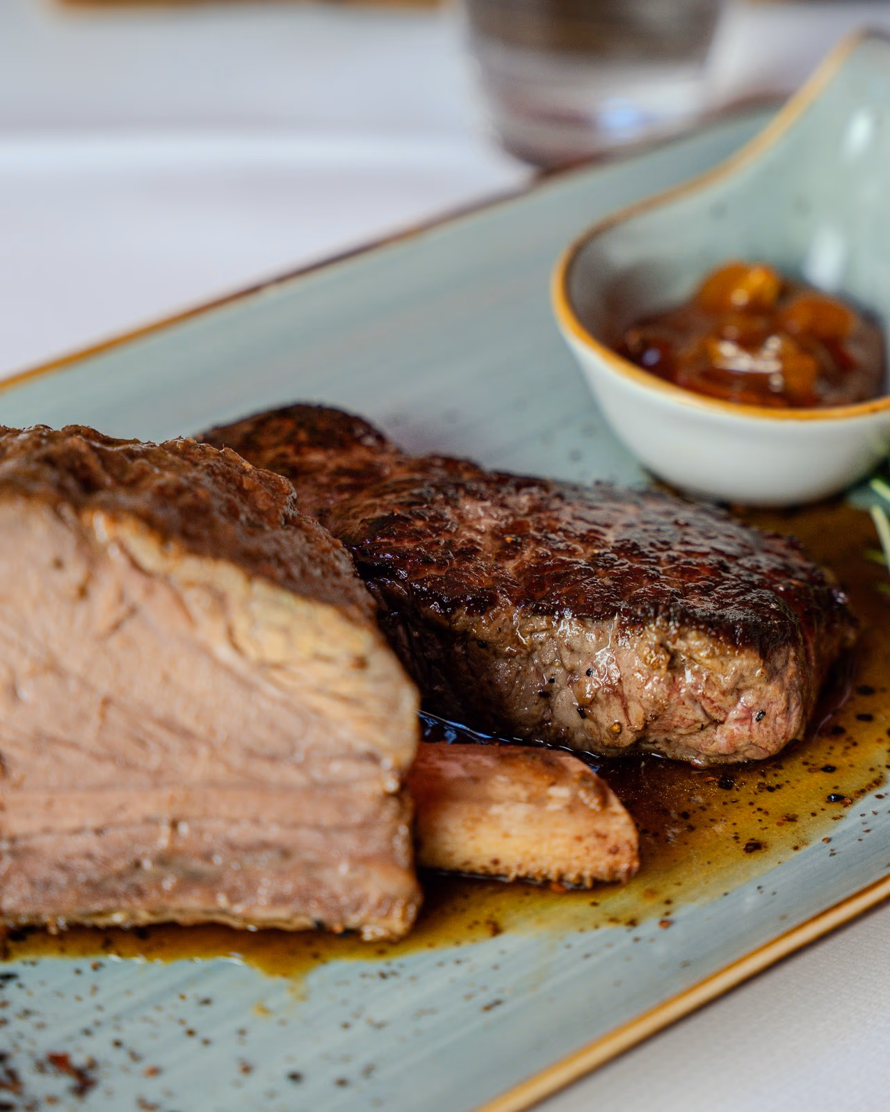 20 Stunden gegarte Ochsenrippe am Knochen und Ochsensteak vom Lavasteingrill mit BBQ-Dip